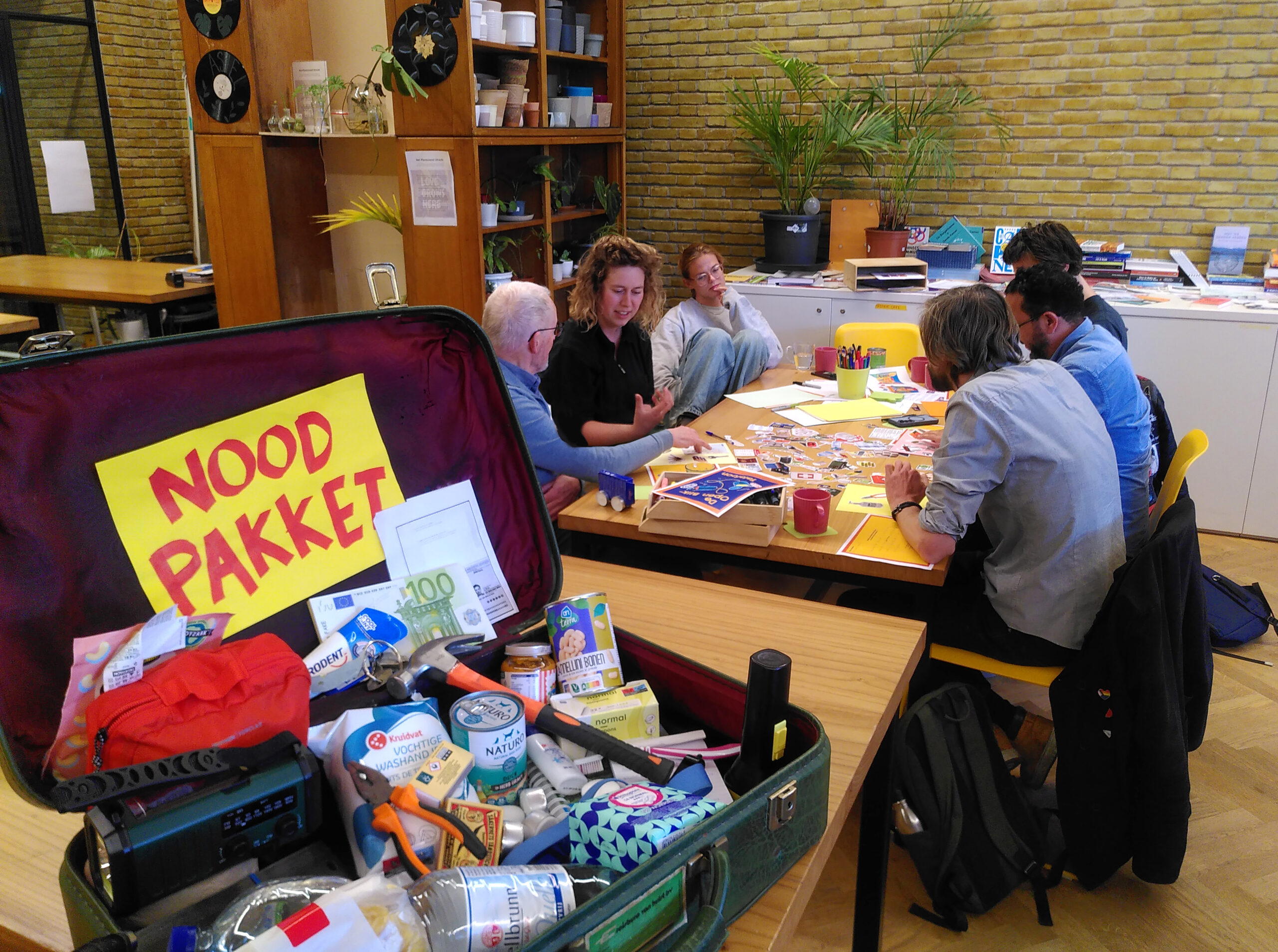 Deelnemers vanuit verschillende burgerinitiatieven volgen een workshop, het Noodpakket vooraan in beeld.